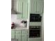 Modern kitchen features mint colored cabinets and stainless steel appliances at 3955 Sweetwater Pkwy, Ellenwood, GA 30294