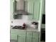 This kitchen boasts a modern range hood and green cabinets at 3955 Sweetwater Pkwy, Ellenwood, GA 30294