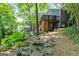Charming backyard with lush greenery, a deck, a patio, and a tranquil rock feature at 610 Lake Dr, Snellville, GA 30039