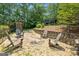 A tranquil backyard retreat with Adirondack chairs arranged around a stone patio and a lush, wooded backdrop at 610 Lake Dr, Snellville, GA 30039