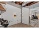 Unfinished basement space with access door and view to a finished area, and bare concrete flooring at 610 Lake Dr, Snellville, GA 30039