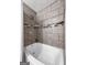 Inviting bathroom with a modern bathtub and tiled shower featuring an elegant decorative tile accent at 610 Lake Dr, Snellville, GA 30039