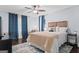 Spacious bedroom features a ceiling fan, hardwood floors, and large windows with blue curtains at 610 Lake Dr, Snellville, GA 30039