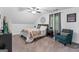 Cozy bedroom with a decorative chair, ceiling fan, and a window with neutral colored curtains at 610 Lake Dr, Snellville, GA 30039