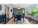 Elegant dining room with a stylish light fixture, large windows with green backyard views and seating for six at 610 Lake Dr, Snellville, GA 30039