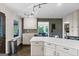 Bright kitchen features white cabinetry, mosaic tile backsplash, and open view to the dining area at 610 Lake Dr, Snellville, GA 30039