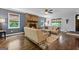 Cozy living room featuring a stone fireplace, hardwood floors, and abundant natural light from multiple windows at 610 Lake Dr, Snellville, GA 30039