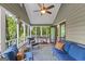 Covered porch with comfortable seating, ceiling fan, and views of backyard trees at 610 Lake Dr, Snellville, GA 30039