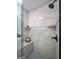 Close up of the walk-in shower with stone tile and built in soap shelves at 610 Lake Dr, Snellville, GA 30039