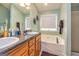 Bright bathroom with dual sinks, vanity, soaking tub, and neutral decor at 345 Morning Star Dr, Temple, GA 30179