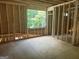 Unfinished attic displaying wood beams and framing, a window for natural light, and staircase construction at 385 Snead, Fayetteville, GA 30215