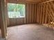 Unfinished attic highlighting exposed wood framing with a window overlooking the serene natural landscape at 385 Snead, Fayetteville, GA 30215
