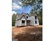 Home exterior under construction with visible frame and roof surrounded by trees and red clay soil at 385 Snead, Fayetteville, GA 30215