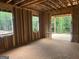 Unfinished living room showcasing wood framing, large windows with scenic views and an outdoor deck area at 385 Snead, Fayetteville, GA 30215