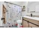Charming bathroom with a floral shower curtain, updated vanity, and modern toilet; a cozy and functional space at 557 Spring Creek Ne Way, Marietta, GA 30068