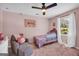 Charming bedroom featuring pink walls, carpet, a ceiling fan, and a cozy chair with an ottoman at 557 Spring Creek Ne Way, Marietta, GA 30068