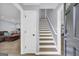 Bright entryway featuring a staircase with white risers, light-gray walls, and a glimpse into the living area at 557 Spring Creek Ne Way, Marietta, GA 30068