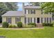 Traditional two-story home with lush landscaping and a classic black front door and shuttered windows at 557 Spring Creek Ne Way, Marietta, GA 30068
