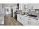 Updated kitchen featuring white cabinets, a tile backsplash, stainless steel appliances, and wood look flooring at 557 Spring Creek Ne Way, Marietta, GA 30068