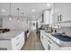 Bright kitchen featuring white cabinetry, gray countertops, stainless steel appliances, and wood-look flooring at 557 Spring Creek Ne Way, Marietta, GA 30068