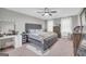 Serene main bedroom with a luxurious upholstered bed, vanity, dresser, ceiling fan, and neutral color palette at 557 Spring Creek Ne Way, Marietta, GA 30068