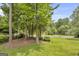Picturesque view of the front yard with mature trees and lush greenery, offering a serene setting at 557 Spring Creek Ne Way, Marietta, GA 30068