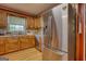 Modern kitchen with wood cabinets, stainless steel refrigerator, and lots of natural light from the window at 12621 Highway 142, Oxford, GA 30054