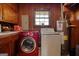 Laundry room featuring a red washer, a dryer, and a hot water heater at 12621 Highway 142, Oxford, GA 30054