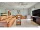 Bright living room with tile flooring, ceiling fans, and comfortable tan leather sofas at 12621 Highway 142, Oxford, GA 30054