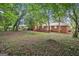 Backyard view of a brick house, green trees and grass at 2858 Valley Ridge Dr, Decatur, GA 30032