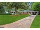 Beautifully landscaped front yard with mature tree and long driveway leading to carport at 2858 Valley Ridge Dr, Decatur, GA 30032