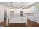 Bright kitchen featuring white cabinetry, a granite island with pendant lighting, stainless steel appliances, and hardwood floors at 3005 Nicholas Dr, Villa Rica, GA 30180