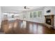 Spacious living room with hardwood floors, stone fireplace, large windows offering plenty of natural light, and a view into the kitchen at 3005 Nicholas Dr, Villa Rica, GA 30180