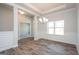 Bright dining area with hardwood floors, decorative wainscoting, and elegant lighting fixture at 267 Eason St, Bowdon, GA 30108