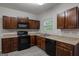 Modern kitchen with granite countertops, dark cabinets, and black appliances at 2137 Chadwick Sw Rd, Atlanta, GA 30331
