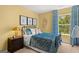 Cozy bedroom featuring a black metal bed frame and yellow walls with natural light from the window at 1404 Gray Branch Dr, Lawrenceville, GA 30045