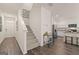 Inviting foyer showcasing a staircase and a modern kitchen with stainless steel appliances at 1404 Gray Branch Dr, Lawrenceville, GA 30045