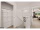 Hallway featuring storage shelves and access to a bedroom overlooking a tree-filled backyard at 1404 Gray Branch Dr, Lawrenceville, GA 30045