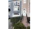 Charming townhome boasts a brick stairway leading to a white door, complemented by gray and peach facade at 3745 Meeting St, Duluth, GA 30096
