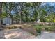 Spacious backyard featuring a brick patio, mature trees, storage shed, and ample room for outdoor activities at 113 Caldwell Dr, Hampton, GA 30228
