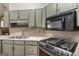 Well-lit kitchen with wood cabinets, stainless steel sink, and range with microwave at 113 Caldwell Dr, Hampton, GA 30228