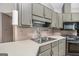 Well-lit kitchen with gray wood cabinets and stainless steel sink and range at 113 Caldwell Dr, Hampton, GA 30228