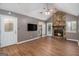 Living room with a stone fireplace, laminate floors, a ceiling fan, and access to laundry at 113 Caldwell Dr, Hampton, GA 30228