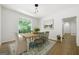 Bright dining room featuring wood table, pendant lighting, and an arched window with backyard views at 1460 Bakers Bridge Rd, Douglasville, GA 30134