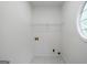 Clean and functional laundry room with tile flooring and wire shelving at 1460 Bakers Bridge Rd, Douglasville, GA 30134