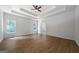Large main bedroom with tray ceiling, ceiling fan, and hardwood floors offer a relaxing retreat at 1460 Bakers Bridge Rd, Douglasville, GA 30134