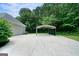 Spacious driveway and carport offering ample parking space next to a detached two-car garage at 1460 Bakers Bridge Rd, Douglasville, GA 30134
