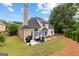 Back exterior view of the home with a patio, green lawn, and beautiful landscaping at 1602 Cascade Overlook, Peachtree City, GA 30269