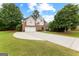 Two-story home featuring manicured lawn, a curved driveway, and lush landscaping at 1602 Cascade Overlook, Peachtree City, GA 30269