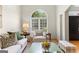 Bright living room featuring hardwood floors, neutral walls, and a large arched window at 1602 Cascade Overlook, Peachtree City, GA 30269